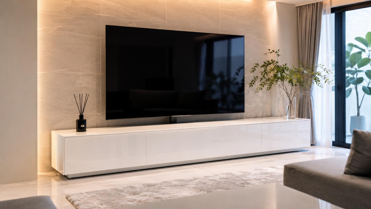 大型テレビの下に光沢のある白いロータイプのシアターボードを配置したモダンなリビング